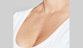 Close-up of woman's neck and décolletage where skin hydration boosters may be applied